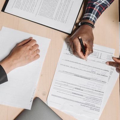Two people reviewing and signing paperwork at a desk
