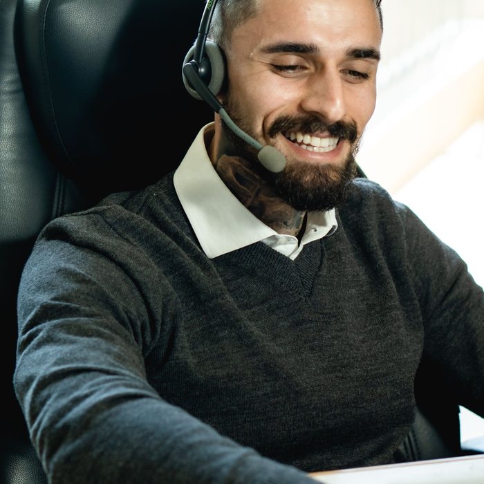 Receptionist wearing a headset, smiling while greeting a caller